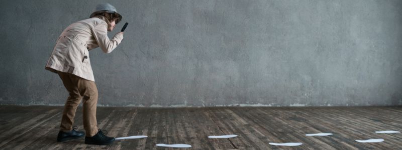 boy in a detective’s outfit tracking footprints | stop tracking company data with spreadsheets